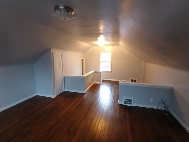 bonus room with dark hardwood / wood-style floors and lofted ceiling