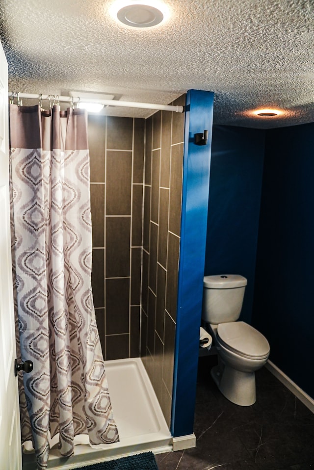 bathroom with toilet and a textured ceiling