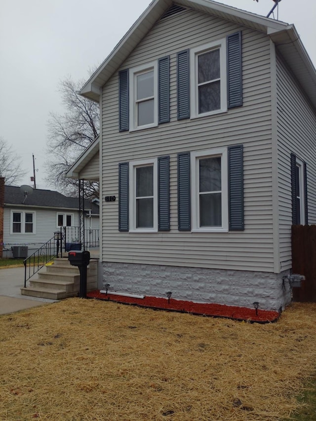 view of front of house featuring a front lawn and central air condition unit