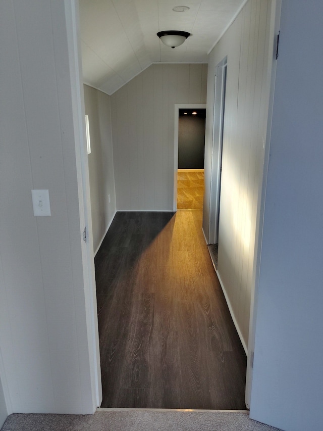 hallway with hardwood / wood-style floors and vaulted ceiling