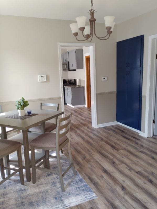 dining room featuring dark hardwood / wood-style floors and an inviting chandelier