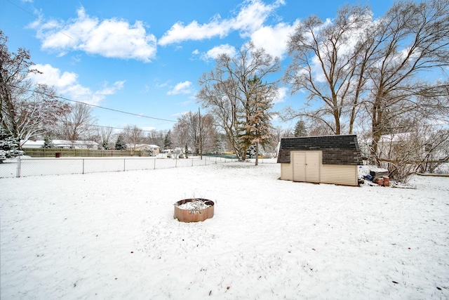 yard layered in snow with a storage unit