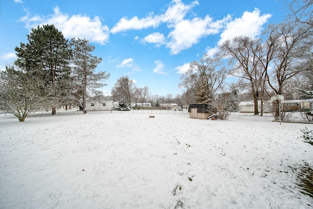 yard layered in snow featuring a storage unit