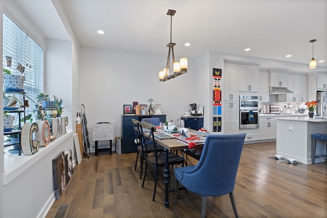 dining space featuring dark hardwood / wood-style floors and a chandelier