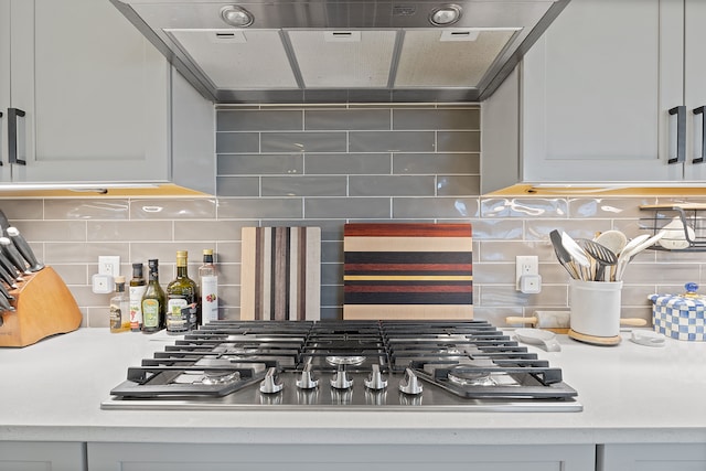 interior details featuring tasteful backsplash, extractor fan, and stainless steel gas cooktop