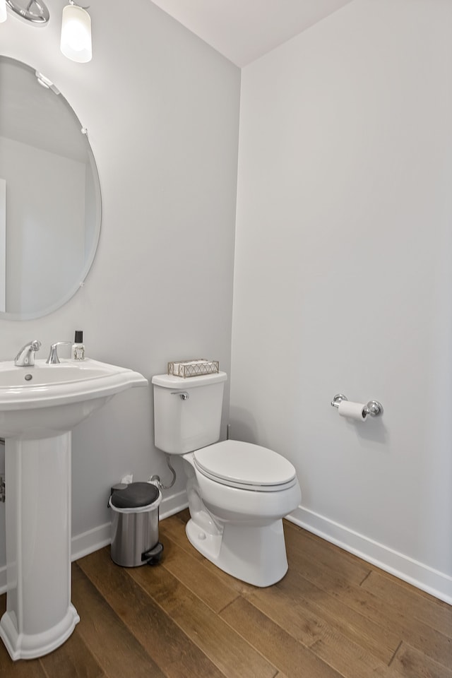 bathroom featuring hardwood / wood-style flooring, toilet, and sink