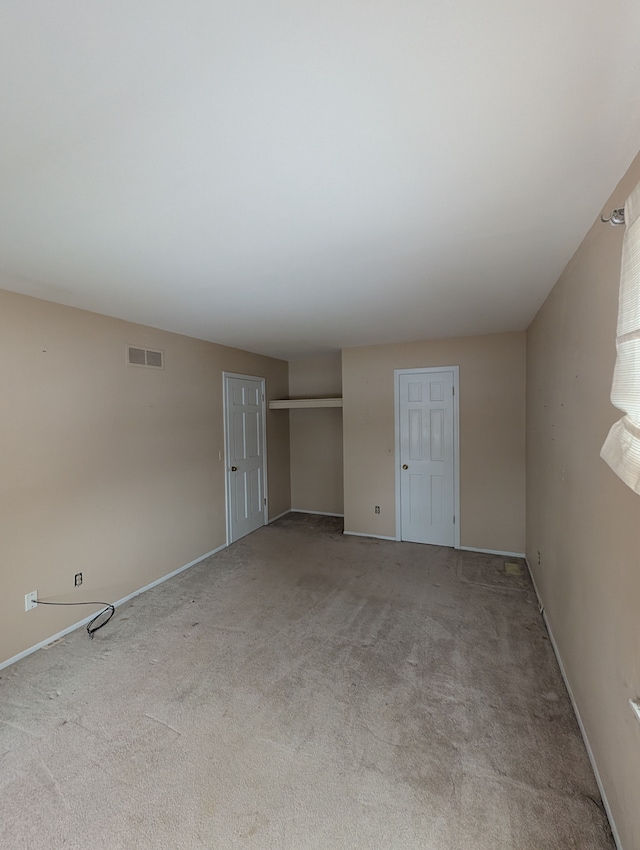 unfurnished bedroom featuring light carpet