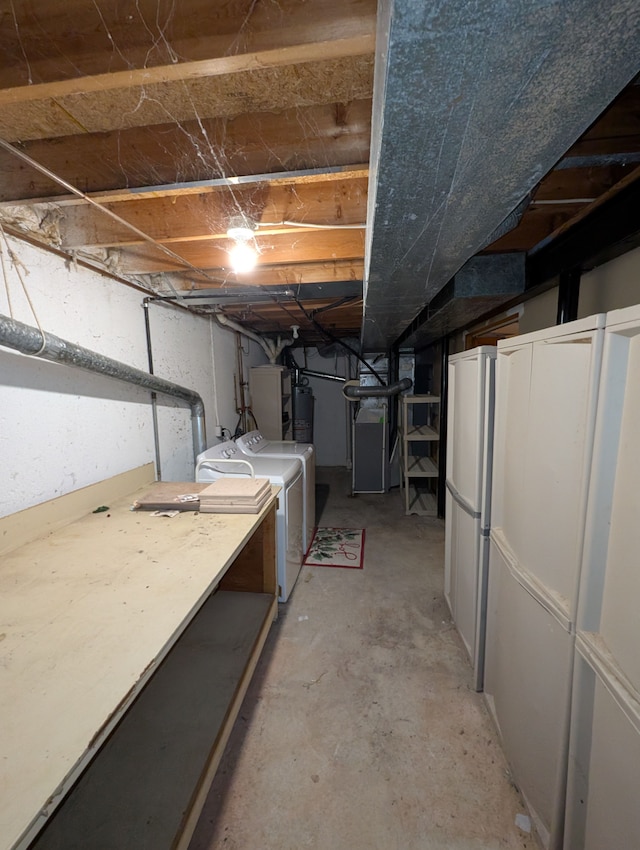 basement featuring heating unit, washer and clothes dryer, and water heater