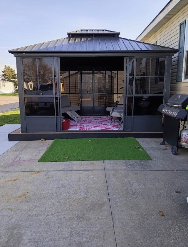 view of patio / terrace featuring a grill and a sunroom