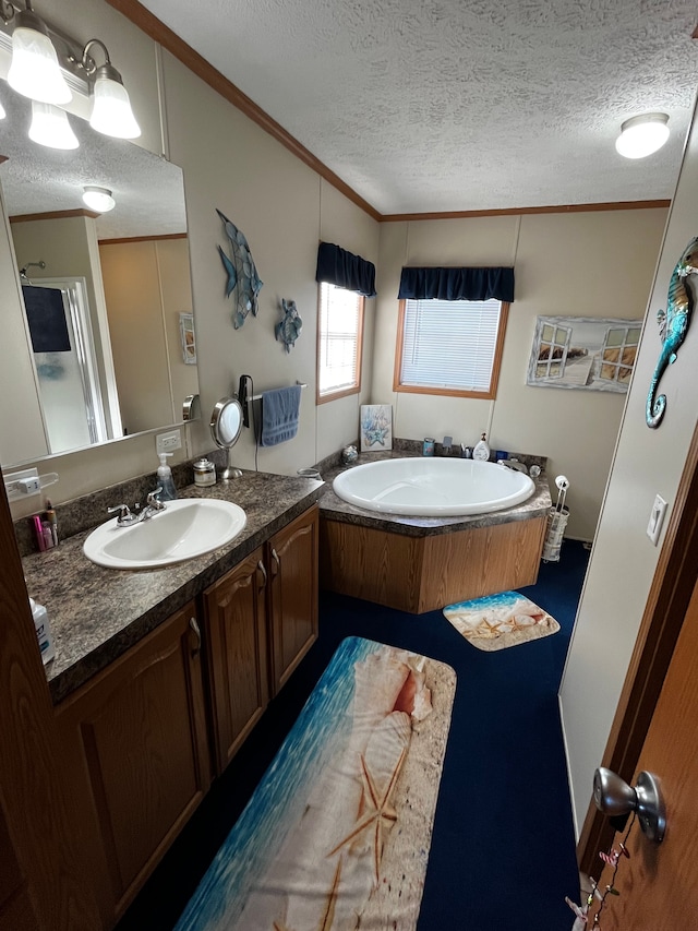 bathroom featuring a bathing tub, vanity, a textured ceiling, and ornamental molding