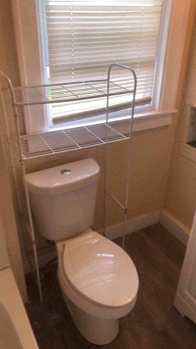 bathroom with hardwood / wood-style flooring and toilet