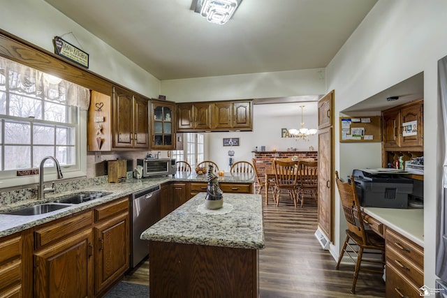 kitchen with dishwasher, sink, a center island, a chandelier, and decorative light fixtures