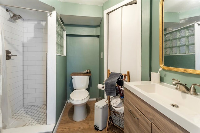 bathroom with vanity, a shower stall, toilet, and wood finished floors