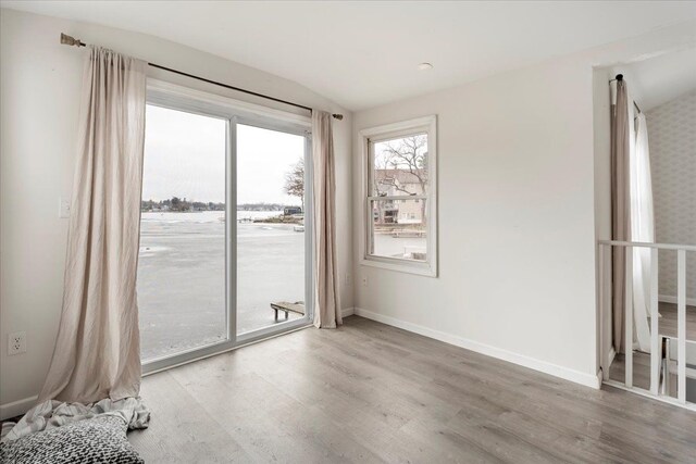 empty room with hardwood / wood-style flooring and vaulted ceiling