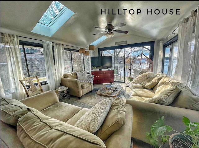 sunroom featuring vaulted ceiling with skylight and a ceiling fan