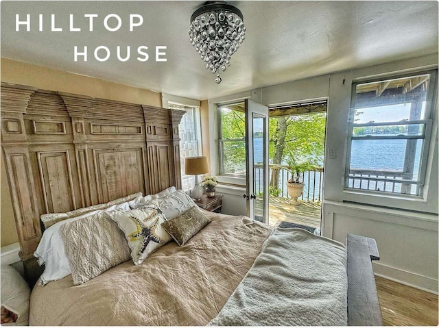 bedroom with access to exterior, baseboards, and wood finished floors