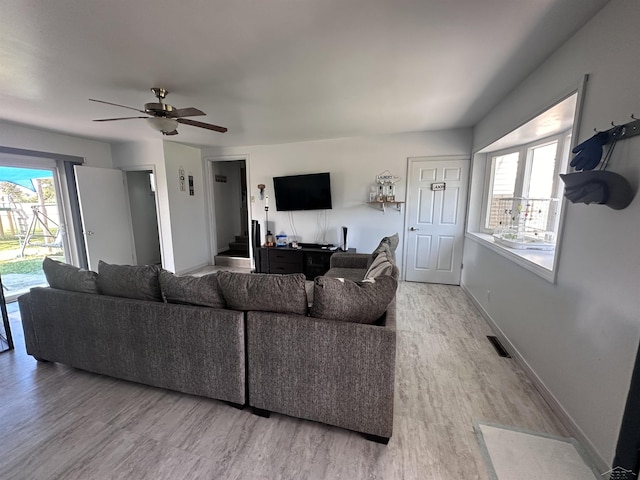 living room featuring ceiling fan and light hardwood / wood-style flooring