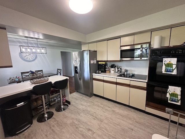 kitchen featuring hanging light fixtures and black appliances