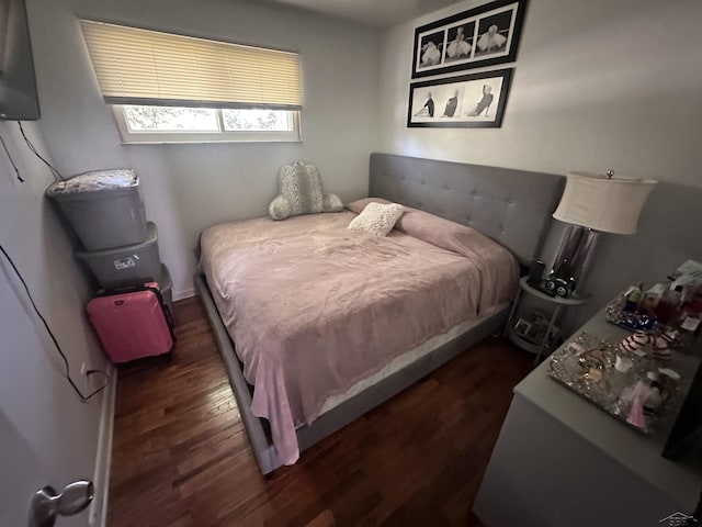 bedroom with dark hardwood / wood-style flooring