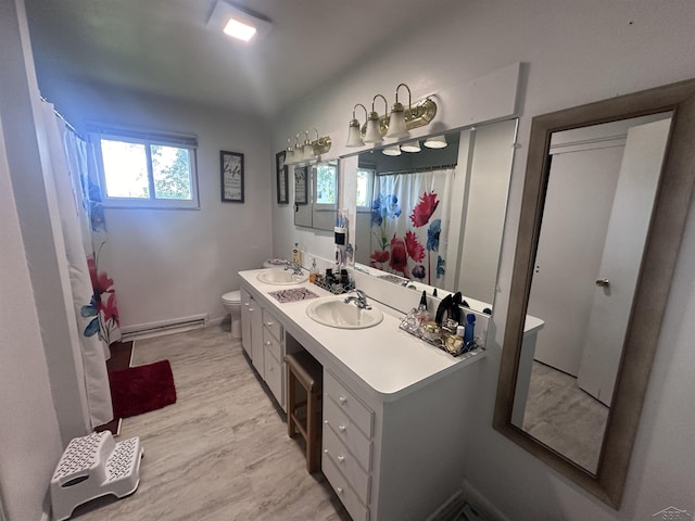 bathroom featuring vanity, hardwood / wood-style floors, toilet, and a baseboard heating unit