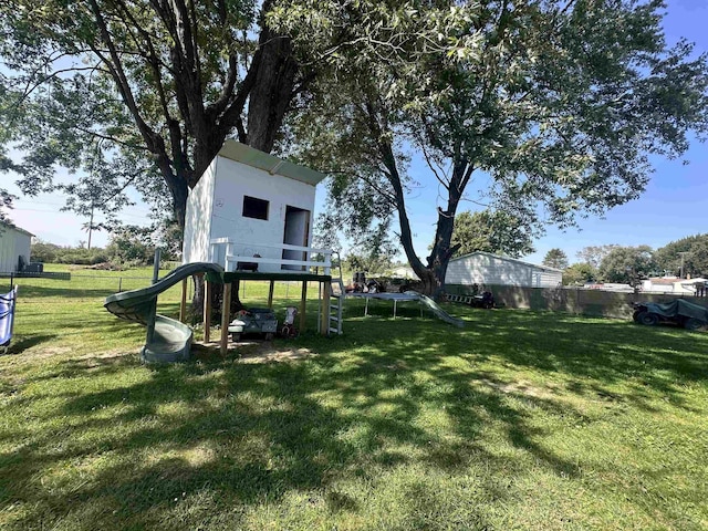 view of yard with a playground and a trampoline