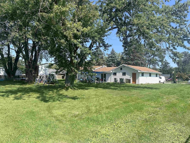 view of front of house with a front lawn and a playground