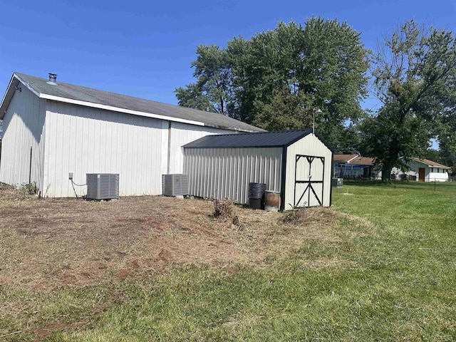 view of outdoor structure featuring a yard and cooling unit