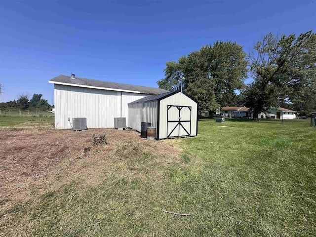 view of outbuilding featuring a yard and central air condition unit