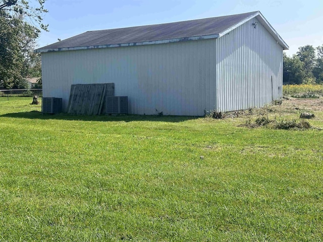 view of outdoor structure featuring central AC and a lawn