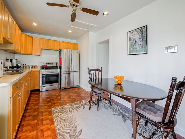 kitchen with dark parquet floors, ceiling fan, sink, and appliances with stainless steel finishes