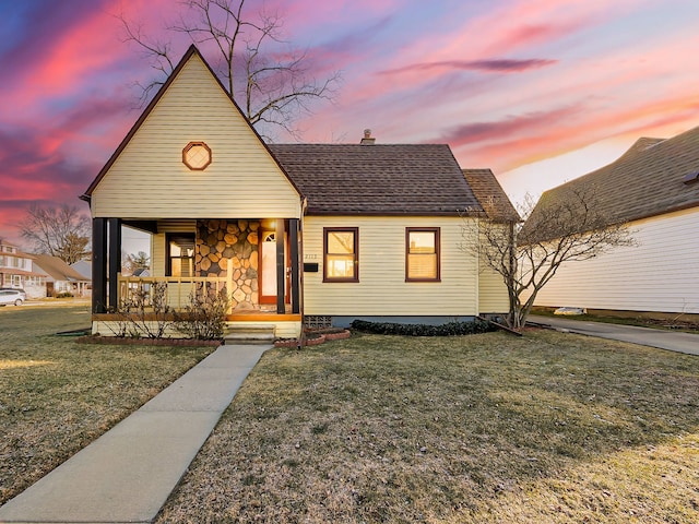 view of front of house featuring covered porch and a yard