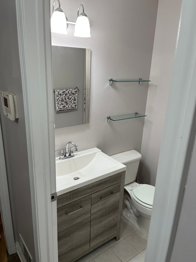 bathroom with tile patterned flooring, vanity, and toilet