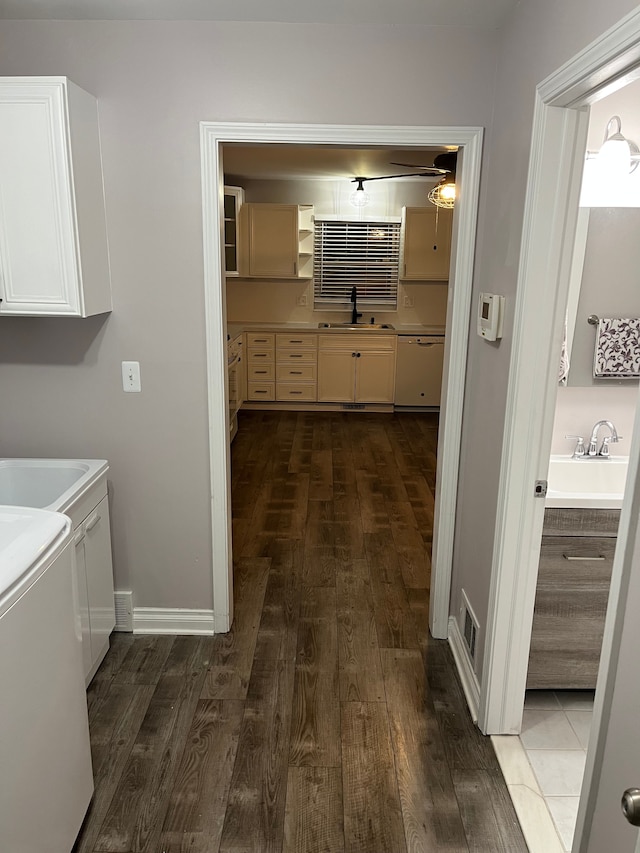 clothes washing area featuring cabinets, washer and clothes dryer, and sink