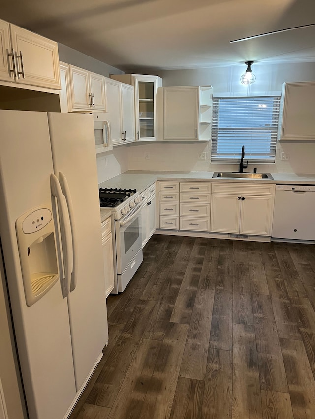 kitchen with white cabinetry, sink, dark hardwood / wood-style floors, and white appliances