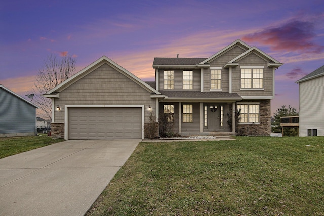 craftsman-style home featuring a garage and a yard