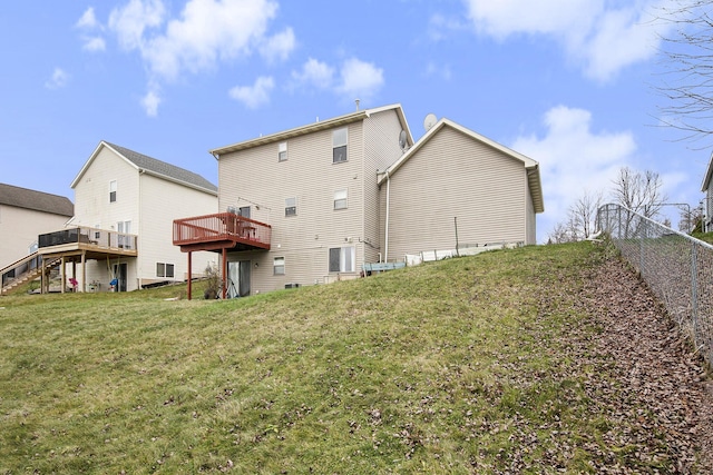 rear view of house with a yard and a wooden deck