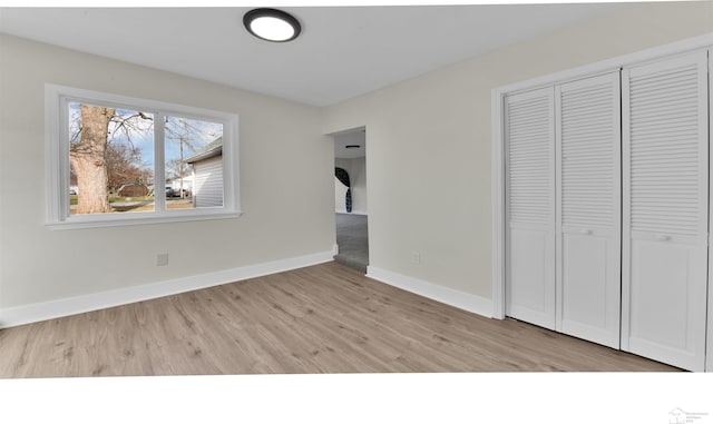 unfurnished bedroom featuring light hardwood / wood-style floors and a closet