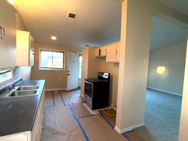 kitchen with sink, stainless steel range with electric cooktop, and light colored carpet