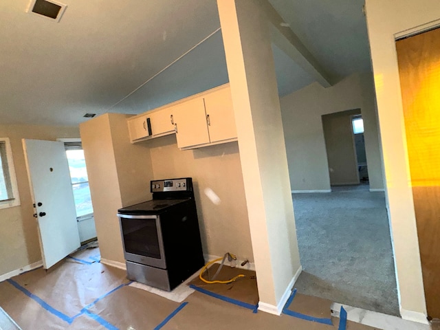 kitchen with lofted ceiling, light colored carpet, and stainless steel range with electric stovetop