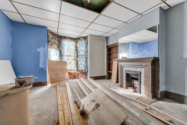 unfurnished living room featuring a drop ceiling