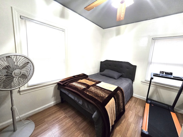 bedroom featuring multiple windows, ceiling fan, and dark hardwood / wood-style floors