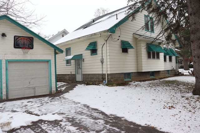 snow covered property featuring a garage