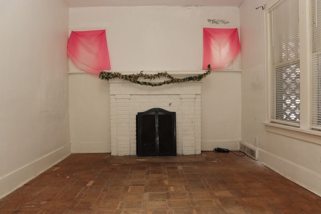 unfurnished living room with a fireplace and dark parquet flooring