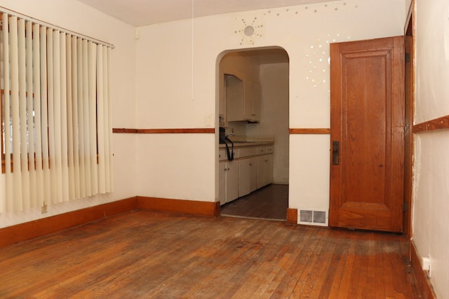 unfurnished room featuring dark hardwood / wood-style flooring and sink