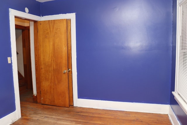 unfurnished bedroom featuring wood-type flooring and a closet