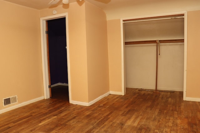 unfurnished bedroom with dark hardwood / wood-style flooring, a closet, and ceiling fan