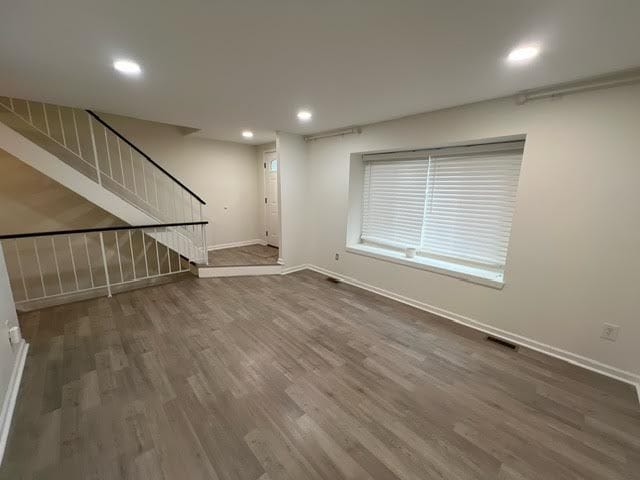 1622 Brentwood Dr, Troy, MI 48098 - unfurnished living room featuring baseboards, dark wood-style floors, stairway, and recessed lighting
