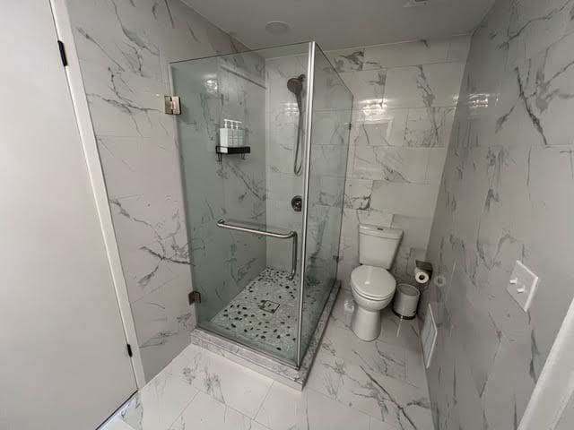 bathroom with walk in shower and toilet