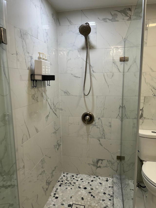 bathroom with toilet and a shower with shower door