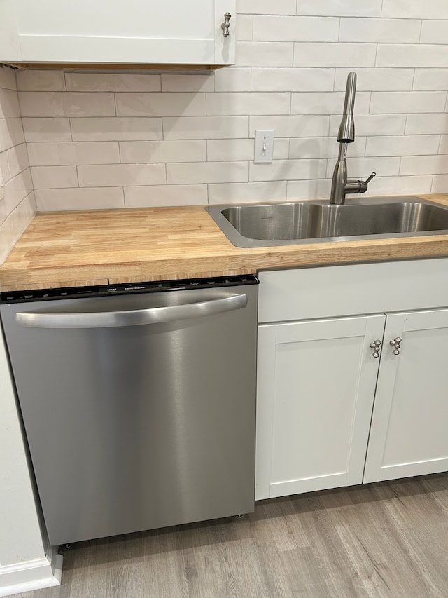 kitchen featuring sink, light hardwood / wood-style flooring, dishwasher, white cabinetry, and backsplash